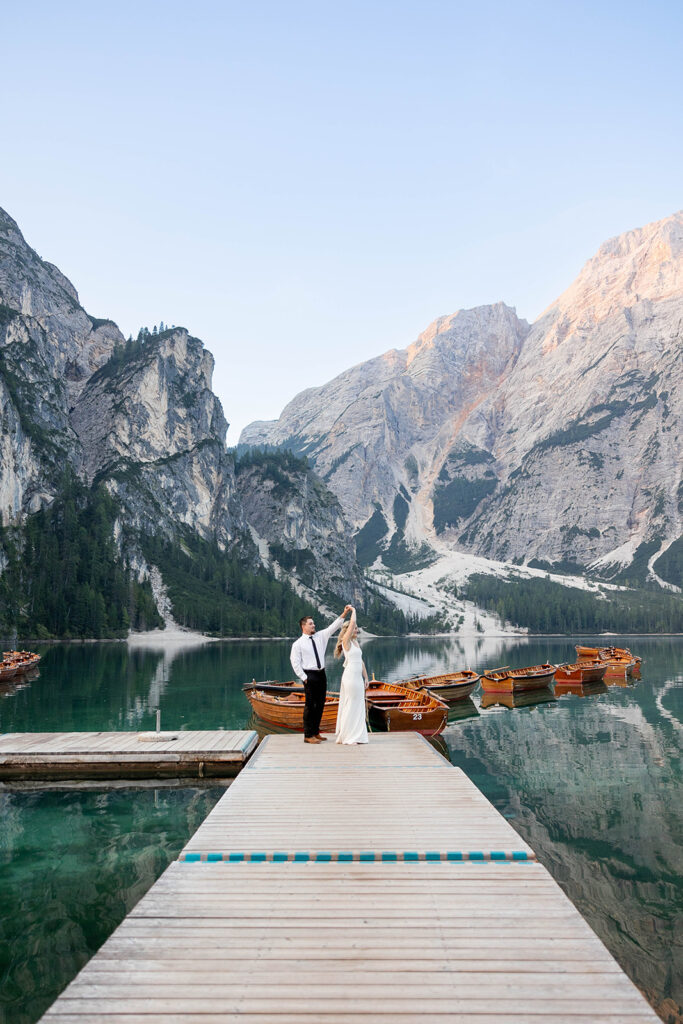 A couple standing together during their destination elopement photoshoot at Lago di Braies in the Dolomites, Italy.
