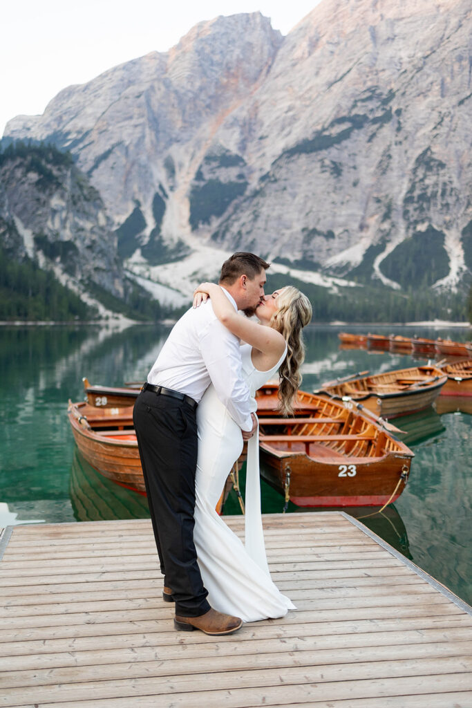 A pair enjoying their elopement photoshoot in the stunning setting of Lago di Braies, surrounded by the Dolomites in Italy.