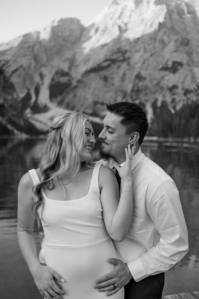 A pair enjoying their elopement photoshoot in the stunning setting of Lago di Braies, surrounded by the Dolomites in Italy.
