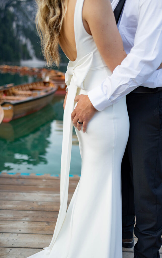 A pair enjoying their elopement photoshoot in the stunning setting of Lago di Braies, surrounded by the Dolomites in Italy.