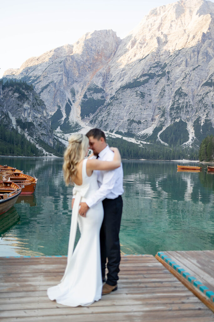 A pair enjoying their elopement photoshoot in the stunning setting of Lago di Braies, surrounded by the Dolomites in Italy.
