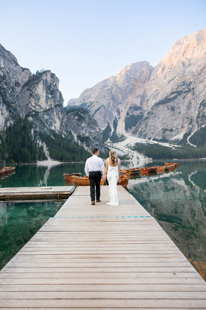 A couple standing together during their destination elopement photoshoot at Lago di Braies in the Dolomites, Italy.
