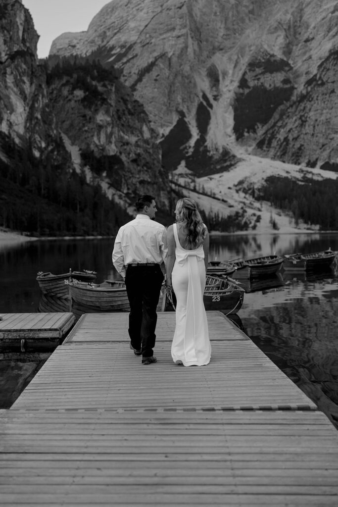 A couple standing together during their destination elopement photoshoot at Lago di Braies in the Dolomites, Italy.
