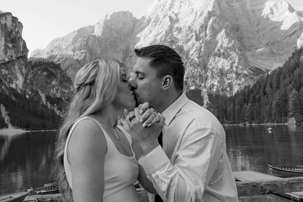 A couple standing together during their destination elopement photoshoot at Lago di Braies in the Dolomites, Italy.
