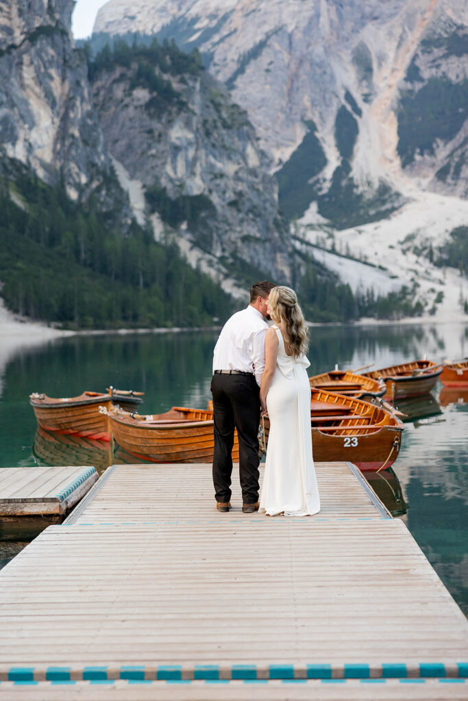 A couple standing together during their destination elopement photoshoot at Lago di Braies in the Dolomites, Italy.
