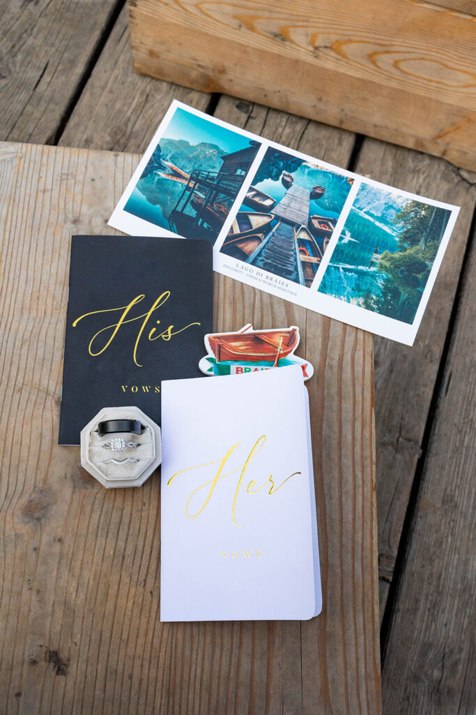 A couple capturing their special elopement moments by the serene waters of Lago di Braies in Italy’s Dolomites
