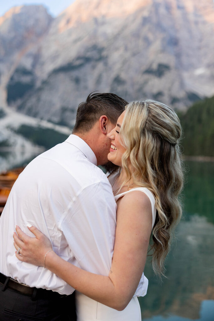 Two people posing by the picturesque Lago di Braies in the Dolomites for their destination elopement photos.