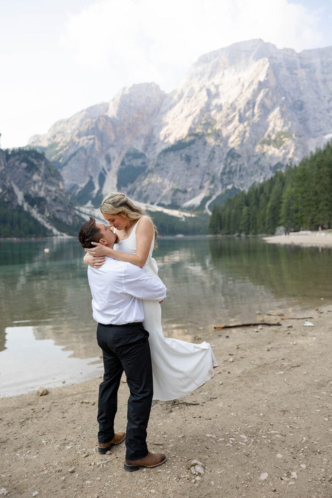 A couple standing together during their destination elopement photoshoot at Lago di Braies in the Dolomites, Italy.