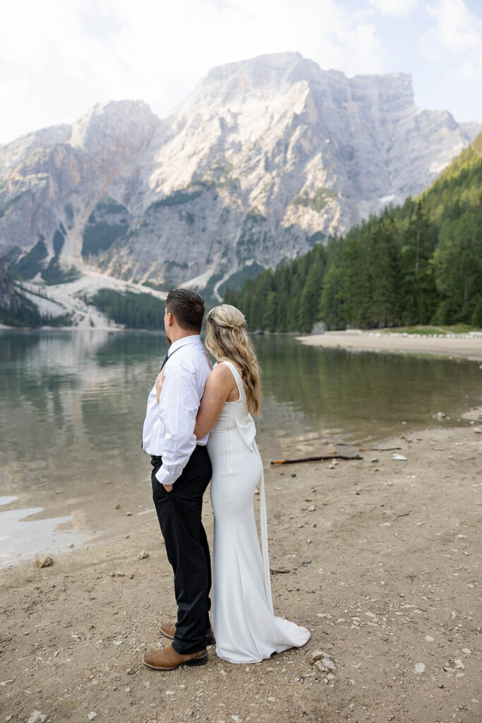 A couple standing together during their destination elopement photoshoot at Lago di Braies in the Dolomites, Italy.
