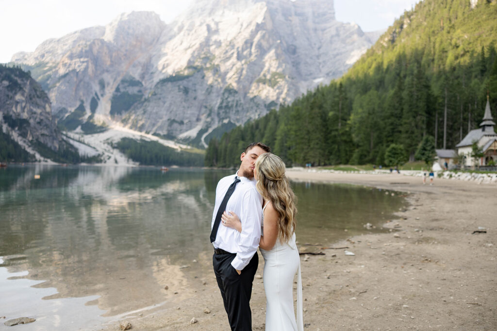 A couple standing together during their destination elopement photoshoot at Lago di Braies in the Dolomites, Italy.
