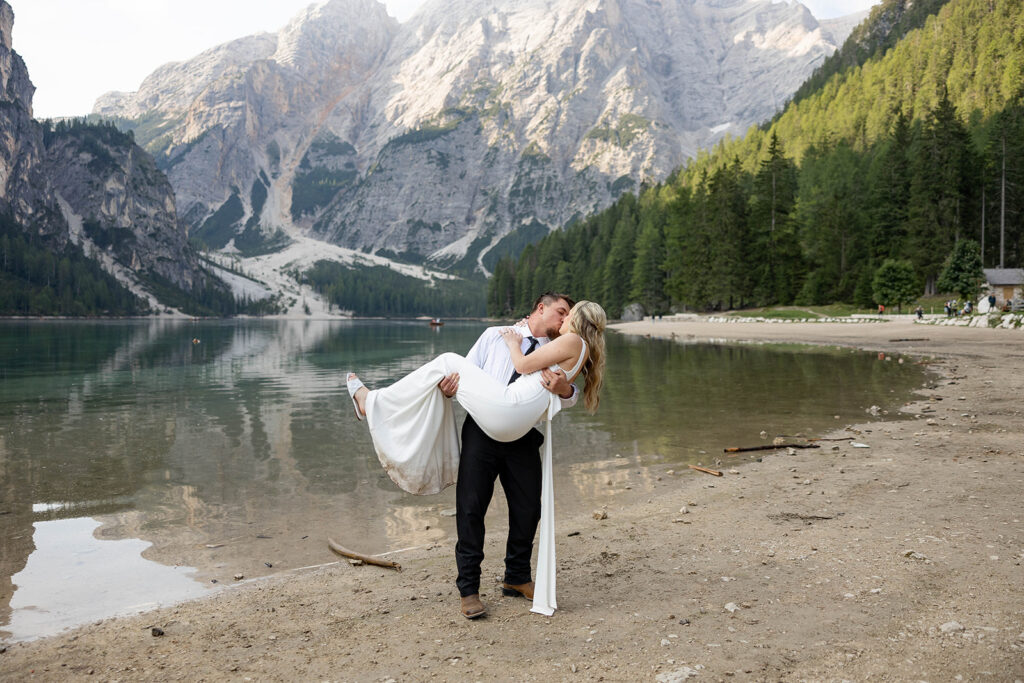 A couple standing together during their destination elopement photoshoot at Lago di Braies in the Dolomites, Italy.
