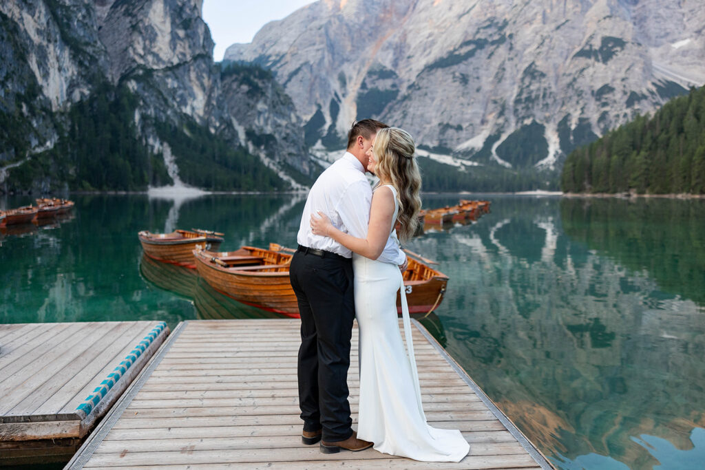 Two people posing by the picturesque Lago di Braies in the Dolomites for their destination elopement photos.
