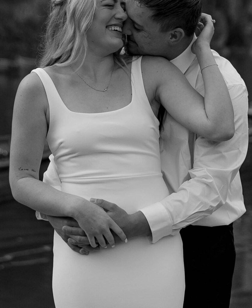 A pair enjoying their elopement photoshoot in the stunning setting of Lago di Braies, surrounded by the Dolomites in Italy.
