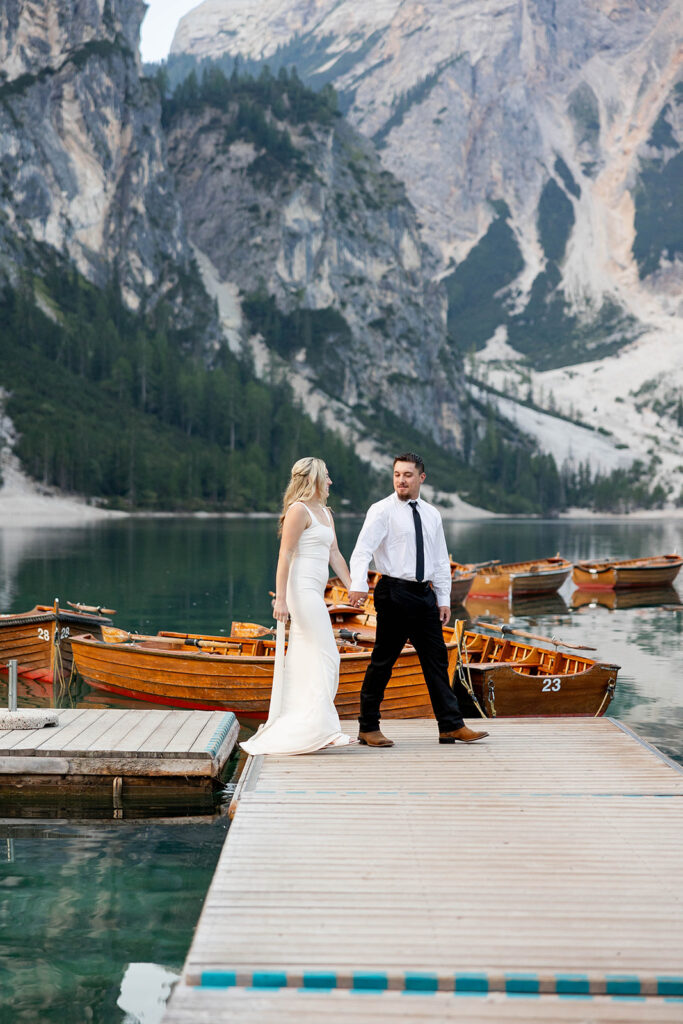 Two people posing by the picturesque Lago di Braies in the Dolomites for their destination elopement photos.
